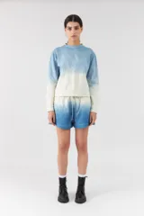 Short de felpa con efecto degradado en tonos blanco y azul, cintura elástica con cordón ajustable y diseño holgado.