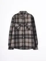 Sobrecamisa de franela a cuadros en tonos grises, negros y marrones, con cuello clásico, cierre frontal de botones y dos bolsillos delanteros con solapa.