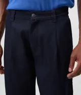 Pantalón de jean azul marino con corte recto y estilo semi sastrero, confeccionado en denim crudo de algodón, con pinzas frontales y trabillas para cinturón.