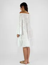 Vestido corto blanco con bordado calado, escote off-shoulder con cordón ajustable y mangas largas acampanadas.