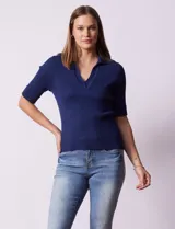 Buzo azul de tejido acanalado, con cuello solapa y escote en V en tejido calado.