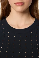 Sweater de punto fino en color negro, con diseño de canalé, cuello redondo y mangas largas. Presenta un corte ajustado con aberturas laterales en el ruedo y está decorado con pequeñas cuentas doradas en la parte frontal.