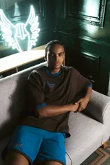 Short deportivo azul con ribete marrón y logo bordado en el muslo.