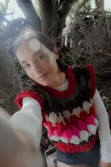 Chaleco tejido de punto con diseño multicolor en bloques horizontales, cuello redondo y sisas amplias.