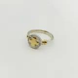 Anillo de enfermería con diseño circular que combina plata 925 y oro 18k, presentando una cruz central en relieve sobre una base texturizada.