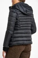 Campera reversible con diseño acolchado, cierre frontal y capucha. Un lado es de color negro y el otro de color tostado, con puños tejidos en color negro.