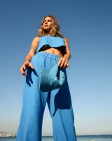 Pantalón oxford azul de lino y rayón, con cintura elastizada, tiro alto y bolsillos laterales.