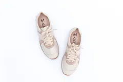 Zapatillas Magnolia de cuero negro con detalles en blanco y suela marrón.