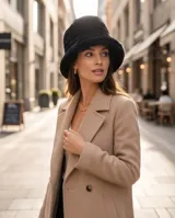 Gorro piluso de piel sintética color negro, con ala corta y caída suave.