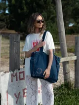 Bolso tipo tote bag confeccionado en denim de color azul oscuro, con costuras reforzadas y diseño espacioso. Cuenta con correas resistentes para llevar al hombro.