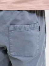 Bermuda de calce relajado color gris, con cintura ajustable con cordón, bolsillos delanteros y traseros, confeccionada en tejido dobby con sutil textura geométrica.