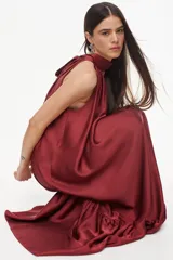 Vestido largo de viscosa color bordó, con cuello halter alto, corte holgado y volante fruncido en el bajo.