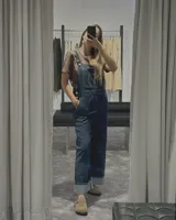 Enterito jardinero de denim azul oscuro, con tirantes ajustables y bolsillos frontales y traseros.