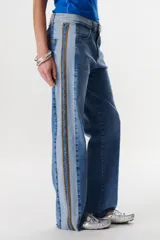 Jean de corte recto y tiro medio, confeccionado en denim con un diseño de lavado en dos tonalidades de azul y detalle de bordado lateral a contratono.