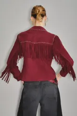 Camisa estilo western color bordó, confeccionada en gamuza caprina, con flecos largos en el canesú delantero y en las mangas. Presenta cuello con tachas metálicas plateadas.