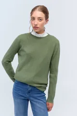 Sweater de punto en color verde oliva, con cuello redondo y mangas largas. Presenta un diseño clásico y minimalista, confeccionado en lana suave.
