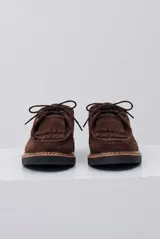 Zapato abotinado de gamuza color caramelo, con cordones, detalle de flecos en el empeine y suela de goma negra con costuras a la vista.