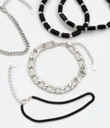 Kit de cinco pulseras de diseño variado, que incluye cadenas de eslabones plateados y pulseras de abalorios y piedras negras. Poseen cierre tipo langosta y cadena de ajuste.