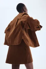 Pollera mini de pana marrón, corte evasé, con cierre y botón frontal.