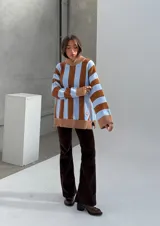 Sweater de punto con cuello alto, a rayas verticales anchas color celeste y marrón, con detalles de lurex en las rayas finas color marrón.