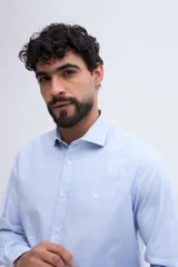 Camisa de manga larga fit semi slim color celeste, con cierre frontal de botones y cuello camisero clásico.