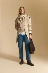 Top tejido sin mangas color negro, con cuello redondo y volados en las sisas con terminación en contraste de punto blanco. Presenta un calce recto y puño inferior acanalado con detalle de punto blanco.