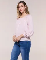 Blusa de modal y elastano color blanco, de silueta holgada, escote redondo amplio con elástico interno fruncido y mangas largas fluidas con puños ajustados.