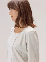 Remera de manga larga con diseño combinado, presenta un panel central de lino en color blanco y laterales de algodón con spandex en tono gris melange, con detalles de vivos en contraste.
