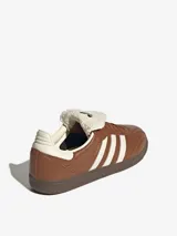 Championes Adidas Samba LT color marrón, con diseño inspirado en el fútbol, exterior de cuero, tres bandas laterales en color crema y lengüeta larga de material texturizado.