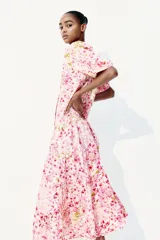 Vestido largo de algodón color rosa con estampado floral, cuello mao, mangas globo cortas, cinturón fino extraíble y falda acampanada con fruncido escalonado.