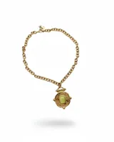 Collar de cadena de eslabones gruesos en acero dorado, con un dije central de diseño circular tipo moneda antigua con textura rugosa y una piedra rectangular clara engastada en el centro.