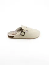 Pantuflas tipo zueco color beige, confeccionadas en material sintético con textura similar a la gamuza. Presentan un diseño cerrado con una tira ajustable lateral con hebilla metálica y forro interior de piel sintética para mayor calidez.