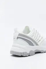 Zapatilla deportiva de estilo trekking con diseño técnico y urbano. Presenta una estructura combinada de paneles de malla y piezas de poliuretano, con sistema de cordones integrado y suela robusta con relieve para mayor estabilidad.