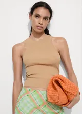 Top color beige de tejido de punto de canalé, con cuello redondo y tirantes anchos. Diseño entallado.