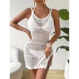 Vestido corto de playa tejido en crochet con diseño calado, cuello redondo y tajo lateral. Presenta un corte ajustado y sin mangas.