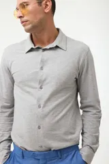 Camisa azul marino de piqué con cuello clásico, manga larga y cierre frontal con botones.