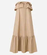 Vestido largo color beige, estilo evasé, confeccionado en tricolina de algodón. Presenta escote hombro a hombro con un volante superpuesto y bajo fruncido.