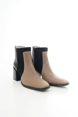 Botas cortas de cuero vacuno en combinación de colores tostado y negro, con diseño bicolor y paneles laterales de gamuza, punta cuadrada y taco bloque ancho.