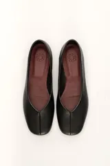 Chatas planas de cuero color plateado metálico, con punta cuadrada y un pequeño tacón bajo de madera.