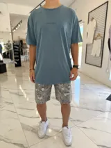 Remera de corte oversize color azul, con efecto gastado y pequeño texto bordado en el pecho.