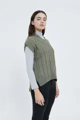 Chaleco tejido color verde oliva con cuello en V y diseño de trenzas.