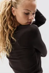 Remera entallada de punto de algodón acanalado color marrón oscuro, con manga larga y cuello redondo.