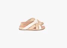 Sandalias planas de cuero con tiras cruzadas en combinación de tonos beige y blanco, plantilla anatómica y suela de poliuretano.
