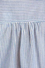 Camisa de manga corta con patrón de rayas verticales en tonos azul y blanco, cuello camisero y cierre frontal con botones.