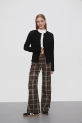 Saco negro de punto, con cuello redondo a la base, manga larga y cierre frontal con botones.