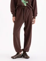 Pantalón tipo jogging de silueta amplia y largo al tobillo, confeccionado en algodón. Cuenta con cintura elastizada, cordón ajustable y bolsillos laterales. Su diseño incluye elásticos en las botamangas que permiten regular el ajuste.
