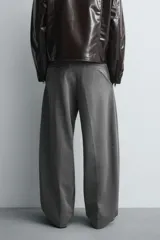 Pantalón de corte balloon fit en color gris, confeccionado en tejido con viscosa. Presenta pliegues frontales, cintura con cinturón integrado a contraste, bolsillos laterales y bolsillos traseros de vivo.