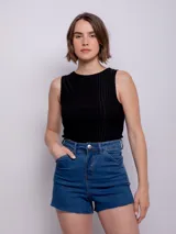 Short de jean negro con cuatro bolsillos, presillas, terminación desflecada, botón y cierre metálico.