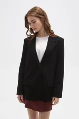 Blazer negro de corte clásico con cuello solapa, cierre frontal con botones y bolsillos laterales con solapa.