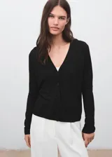 Cardigan de punto fino color negro, con escote en V, manga larga y cierre delantero con botones.